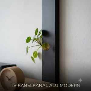 A modern TV cable cover in matte black aluminum on a light wall.